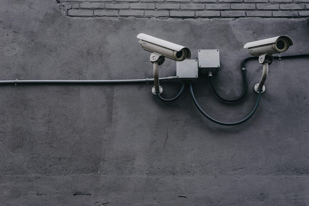 pexels-photo-430208-430208 Two surveillance cameras mounted on a concrete wall, highlighting security technology.